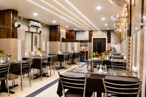 a restaurant with tables and chairs in a room at Hotel Sri Ram in Similigurha