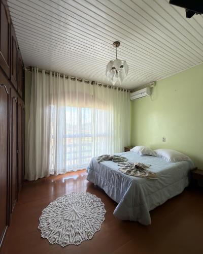 a bedroom with a bed and a large window at Casa Bella Vita in Pinto Bandeira
