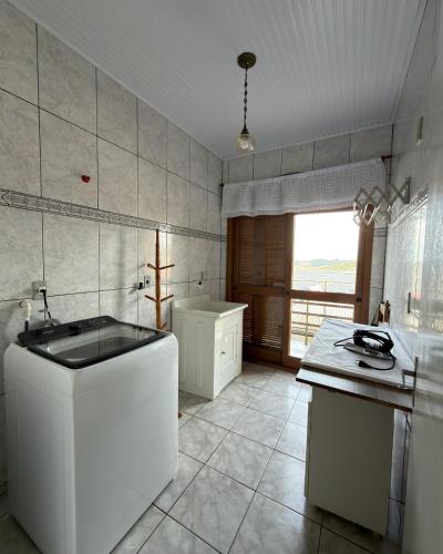 a white kitchen with a sink and a tub at Casa Bella Vita in Pinto Bandeira
