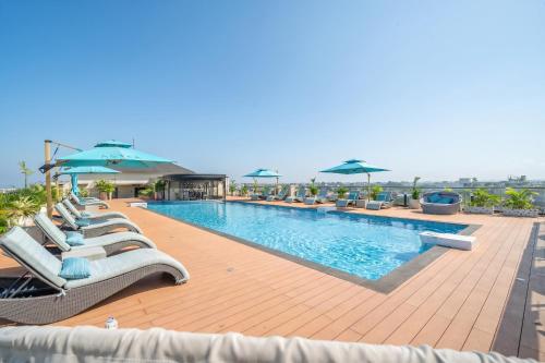 a swimming pool with lounge chairs and umbrellas at Aster Apartments - Stylish Loft with Rooftop Pool & Sauna in Canggu