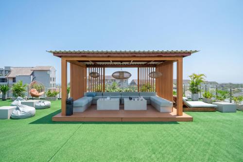 a gazebo with couches on a lawn at Aster Apartments - Stylish Loft with Rooftop Pool & Sauna in Canggu
