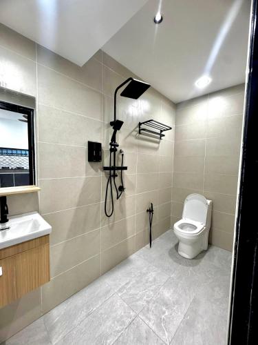 a bathroom with a toilet and a sink at Ujang Guest House 2 in Batu Kikir