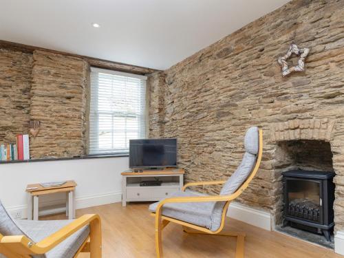 a living room with two chairs and a fireplace at Dayan Cottage in Fowey
