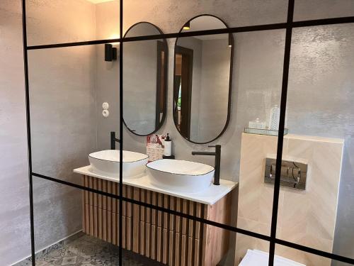 a bathroom with two sinks and two mirrors at Comfortable Jacuzzi Apartment for 8 in Stezyca in Stężyca