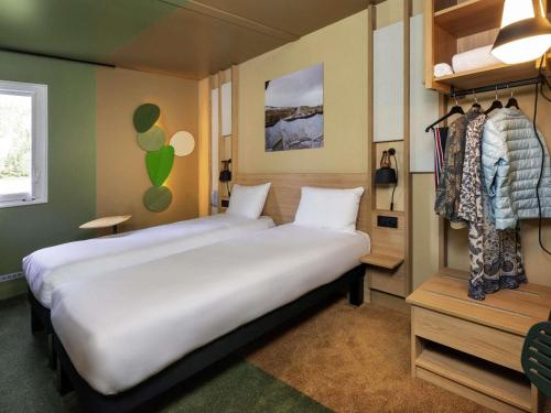 a bedroom with a large white bed and a closet at IBIS STYLES Rouen Parc Expos Zenith in Saint-Étienne-du-Rouvray