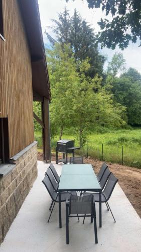 a patio with a table and chairs and a grill at Maison familiale in La Souterraine