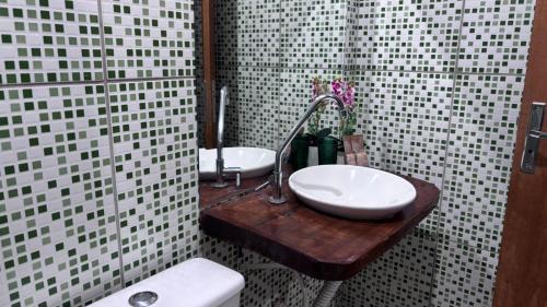 a bathroom with two sinks and a toilet in a shower at Pousada Moaçara in Estivado