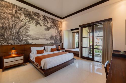 a bedroom with a bed and a painting on the wall at Ranggen Ubud in Ubud
