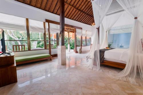 a bedroom with a bed with mosquito net at Alam Bidadari Seminyak in Seminyak