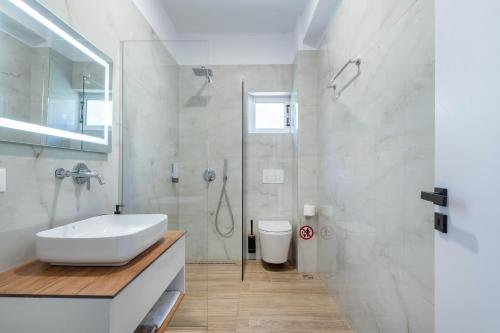 a white bathroom with a sink and a shower at Villa Virginia in Sarandë