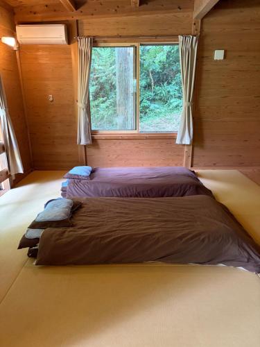 a large bed in a room with a window at YAMAYA BASE 2 in Miyoshi
