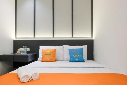 a bedroom with a bed with two pillows on it at SANS Vibes Surya in Stasiun Tawang