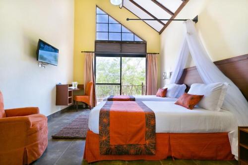 a bedroom with a bed and a large window at Sagana Getaway Resort in Maranjua