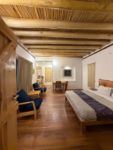 a bedroom with two beds and a living room at Nubra Ecolodge in Liekzan