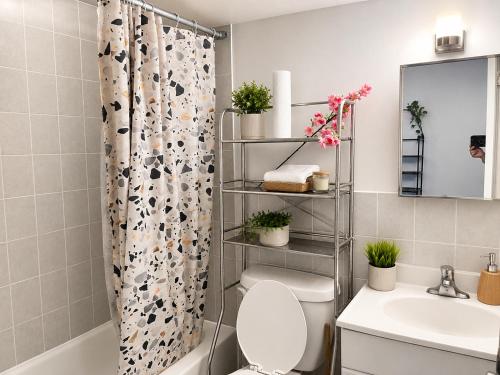 a bathroom with a toilet and a shower curtain at ChinaTown Boutique Rooms in Toronto