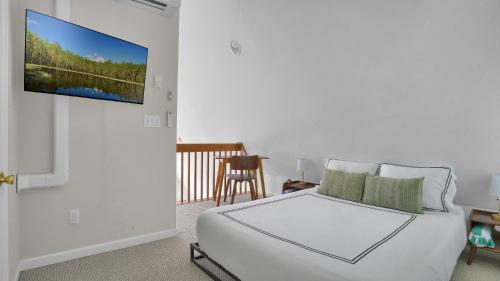 a bedroom with a bed and a tv on a wall at Waterfront, Hot Tub, Dock Kayaks, Movie Game Room in Lake Ariel