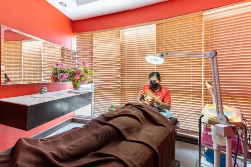 a man wearing a mask sitting in a bathroom at Crown Regency Hotel & Towers in Cebu City