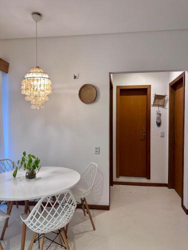 a dining room with a table and chairs and a chandelier at Manay Preá, apartamento 2 quartos na melhor localização do Preá in Cruz