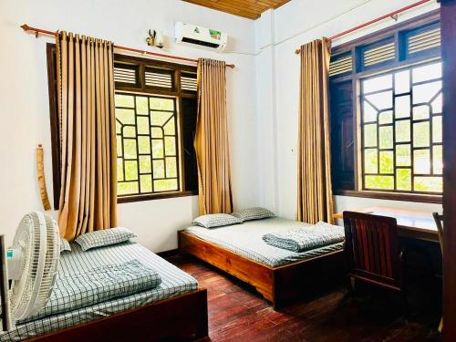 a bedroom with two beds and a window at Roll Huynh in Kon Plong