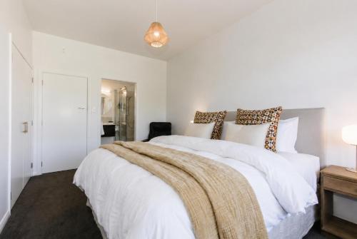 a bedroom with a white bed with a blanket on it at Tresco Apartments - Quiet Luxury in the Heart of Blenheim in Blenheim