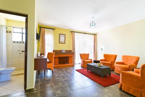 a living room with orange chairs and a bathroom at Sagana Getaway Resort in Maranjua
