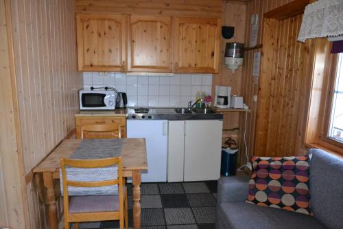 a small kitchen with a table and a microwave at Alta River Camping in Alta