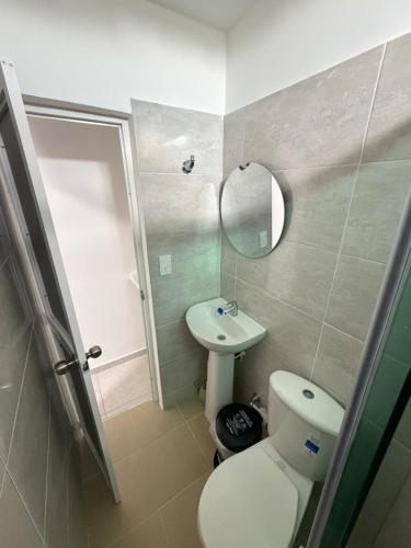 a bathroom with a toilet and a sink and a mirror at Hostal La Marina in Santa Marta