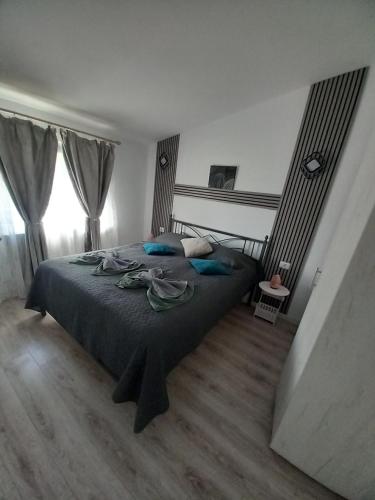 a bedroom with a large bed with blue pillows at Perfect view cottage with pool in Buhalniţa
