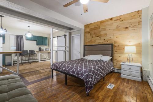 a bedroom with a bed and a wooden wall at Rustic Private Studio Near Downtown Worcester in Worcester