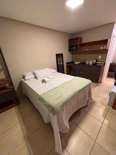 a bedroom with a bed with a green blanket on it at Blume Suítes Premium Orla in Petrolina