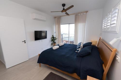 a bedroom with a large bed with a blue blanket at Quampi House with Best Ocean View in Point Lookout