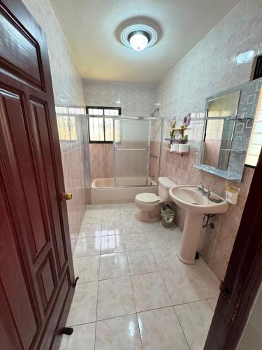 a bathroom with a toilet and a sink and a tub at Hotel1325 in Baní