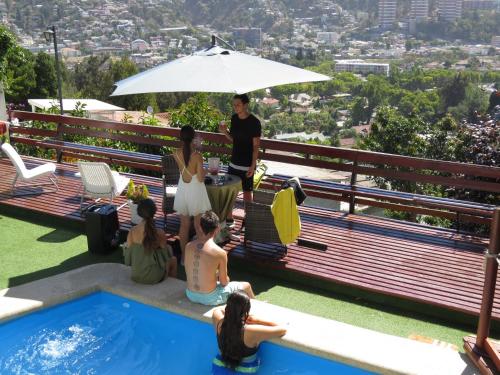a group of people sitting around a pool on a roof at Posada Verde Natura in Viña del Mar