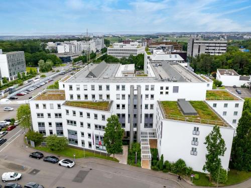 an office building with a green roof on top of it at Mercure Hotel Stuttgart Airport Messe in Stuttgart