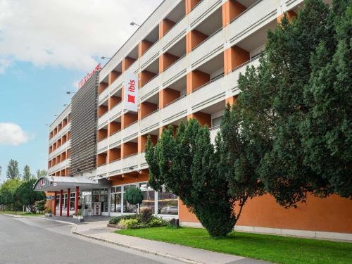 an apartment building with a tree in front of it at Ibis Budapest Citysouth in Budapest