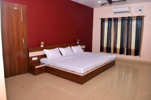 a bedroom with a large bed with white sheets at Lagna Mahal in Birnon