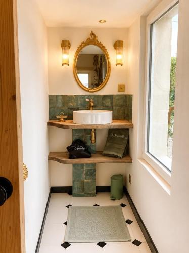 a bathroom with a sink and a mirror at Ô Dentelles in Vacqueyras