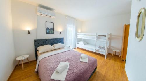 a bedroom with a large bed with a purple blanket at DalEro Sunset Apartments Medjugorje in Međugorje