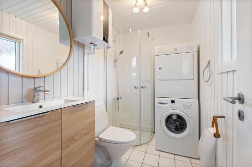 a bathroom with a toilet sink and a washing machine at Feriehus 1120 in Ringkøbing