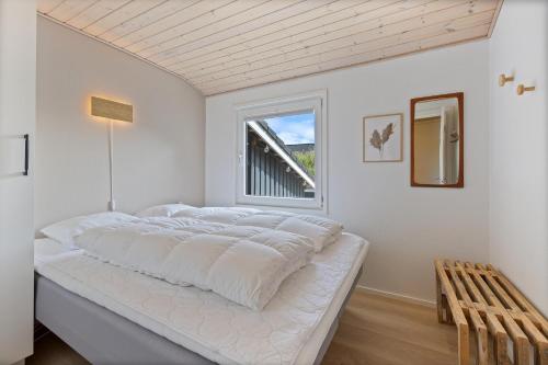 a large bed in a room with a window at Feriehus 1120 in Ringkøbing