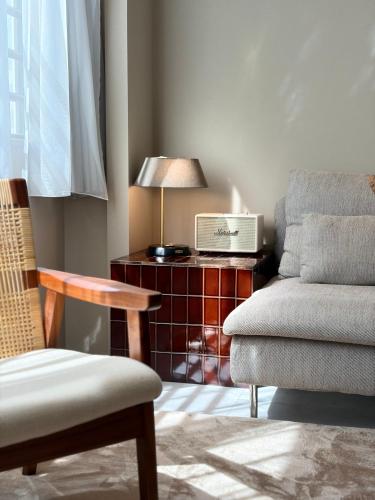 a living room with a chair and a table with a lamp at TABISAI HOTEL Premium 博多-中洲 in Fukuoka
