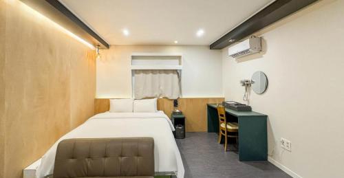a hotel room with a bed and a desk and a bed sidx sidx sidx at Hotel Barley Field Seoknam in Incheon