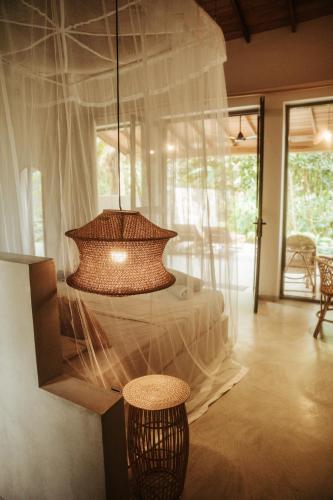 a large room with a bed with a chandelier at DreamTime in Hikkaduwa