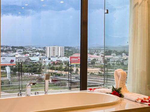 a bathroom with a tub and a large window at Indochine Hotel in Kon Tum (2)