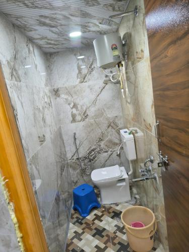 a small bathroom with a toilet and a shower at krishna yadav homestay in Hospet