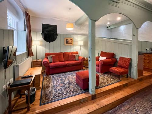 a living room with two red couches and a tv at Saddle Room - Uk51017 in Louth