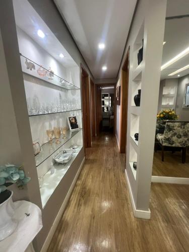 a hallway with glass shelves and a dining room at Apartamento de 3 quartos, climatizado com lazer completo in Brasília