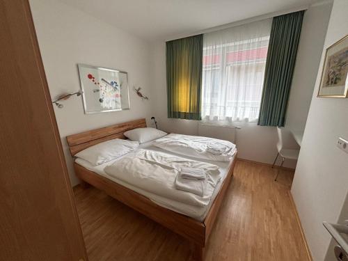 a bedroom with a bed with white sheets and a window at My Adventure Appartements by Schladmingurlaub - 150 Meter zur Gondel in Schladming
