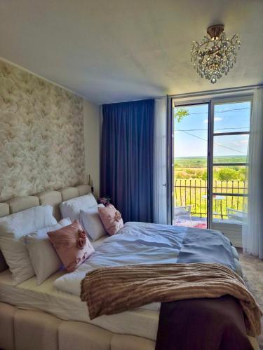 a bedroom with a large bed with a large window at Gyémánt Vendégház in Doba