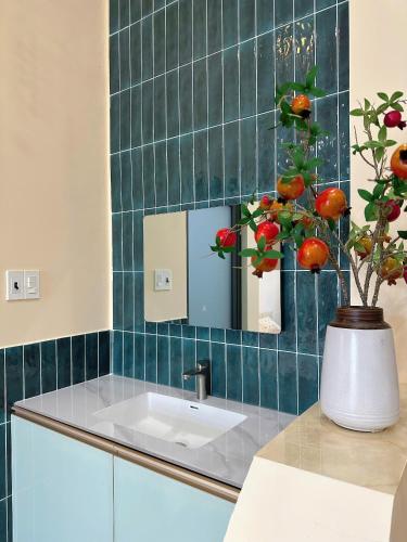 a bathroom with a sink and a vase with a plant at Phố Homestay Phan Thiết in Phan Thiet